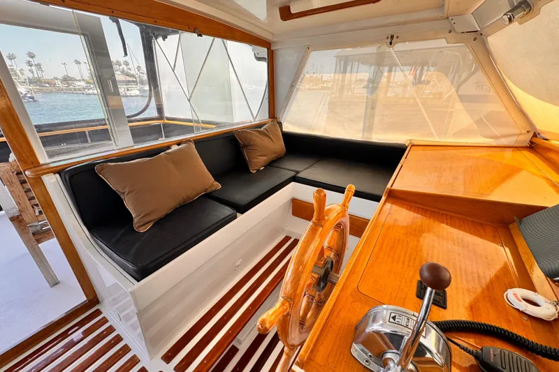 Slide: The Image of Interior of a 1978 Roughwater 41 boat with wooden helm and cushioned seating. - 41