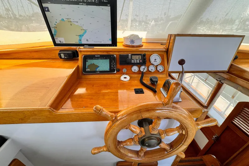 Slide: The Image of 1978 Roughwater 41 boat helm with wooden wheel, navigation screens, and control instruments. - 44