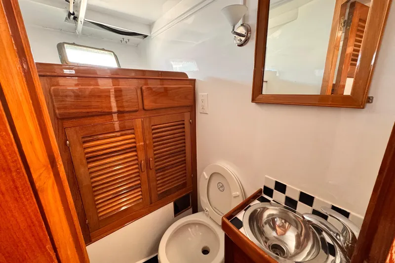 Slide: The Image of 1978 Roughwater 41 yacht bathroom with wooden cabinets and stainless steel sink. - 49