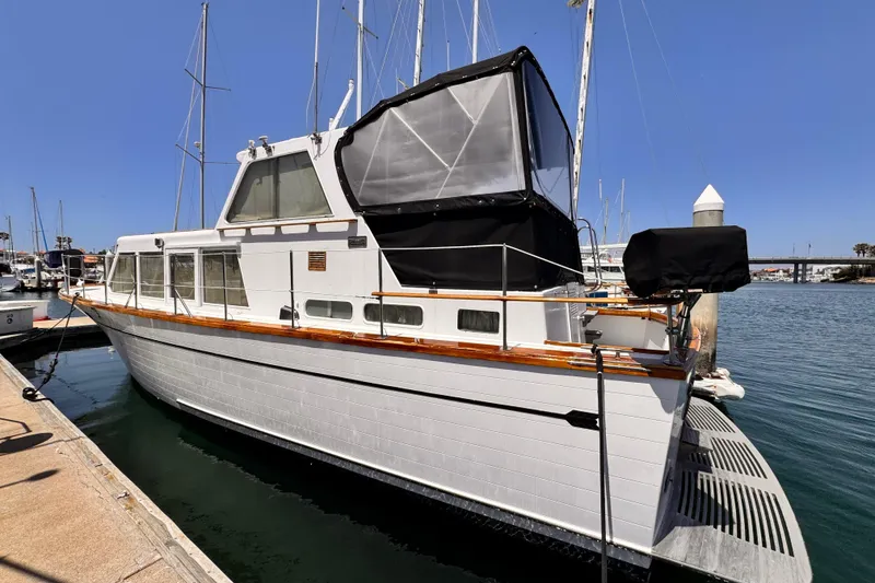 Slide: The Image of 1978 Roughwater 41 yacht docked at marina under clear blue sky. - 5