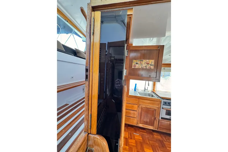 Slide: The Image of Interior view of 1978 Roughwater 41 boat, featuring wooden cabinetry and kitchen area. - 50