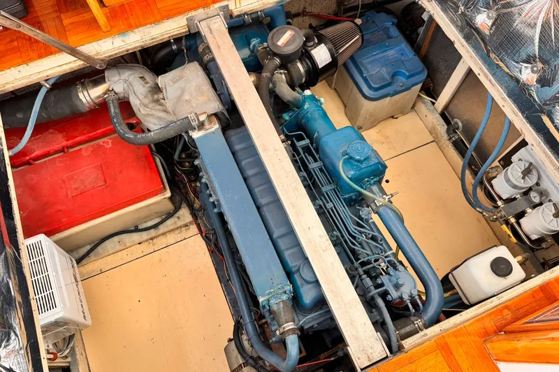 Slide: The Image of Engine compartment of a 1978 Roughwater 41 boat, showcasing a blue marine engine. - 54