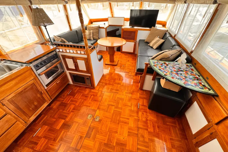 Slide: The Image of 1978 Roughwater 41 yacht interior with wood flooring, kitchen, seating area, and TV. - 6