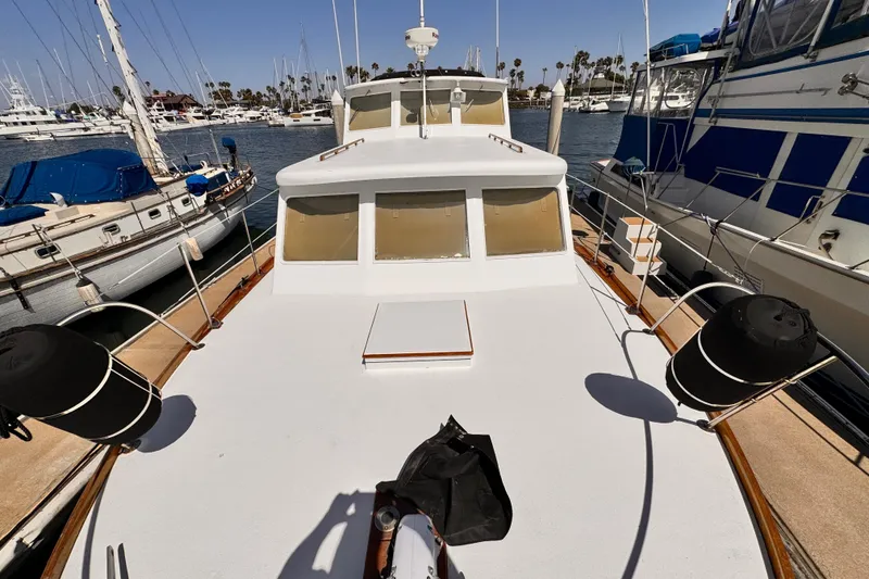 Slide: The Image of 1978 Roughwater 41 boat docked at marina, surrounded by other vessels. - 64