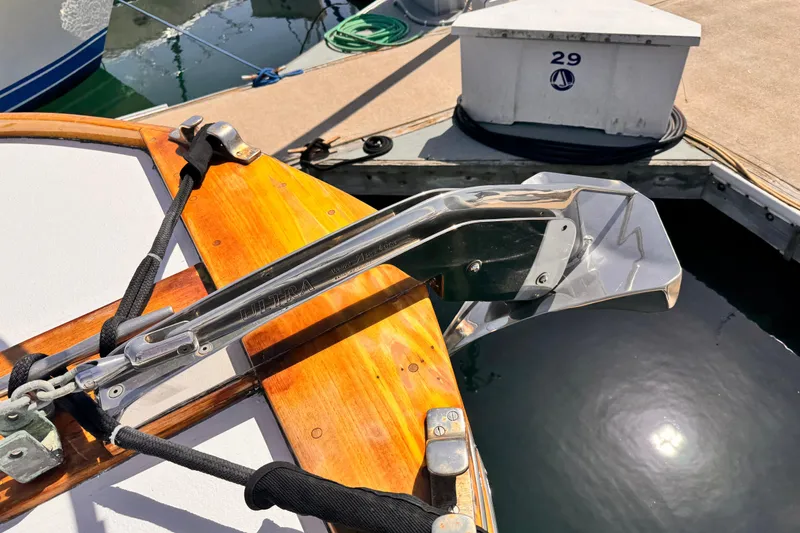Slide: The Image of 1978 Roughwater 41 boat anchor detail with polished metal and wooden deck at marina. - 67