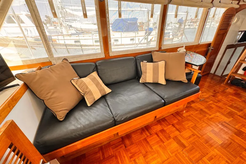 Slide: The Image of Interior of 1978 Roughwater 41 yacht with black leather sofa and decorative pillows. - 8