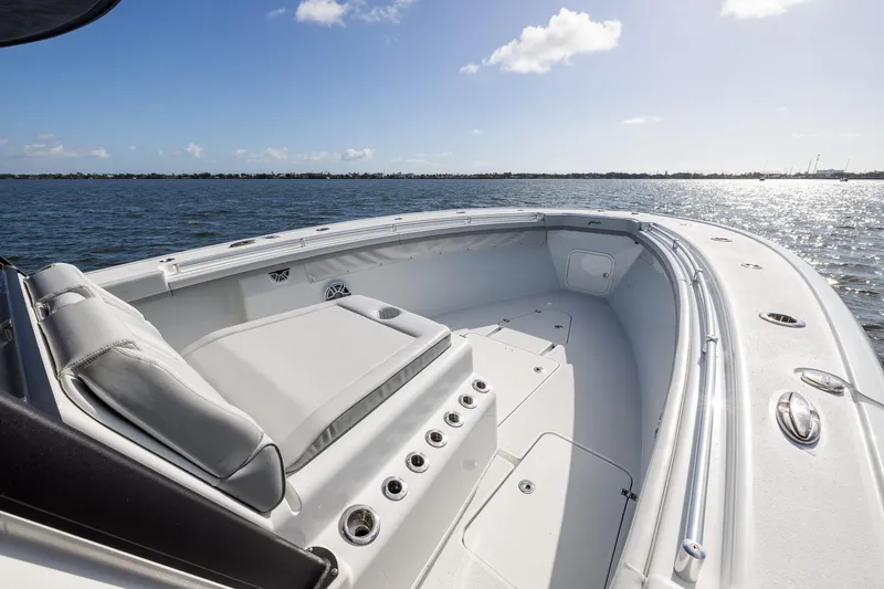 Slide: The Image of 2023 Yellowfin 42 Offshore boat deck with seating, on calm water under blue sky. - 12