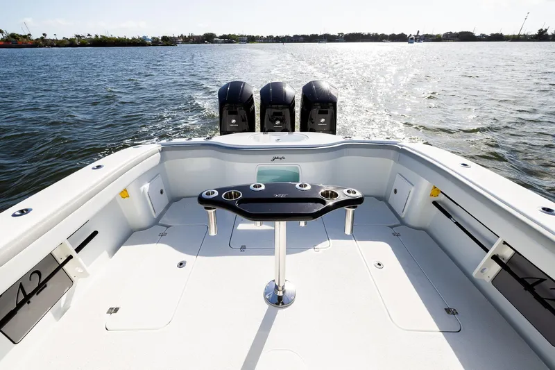 Slide: The Image of 2023 Yellowfin 42 Offshore boat deck with triple outboard motors on open water. - 33