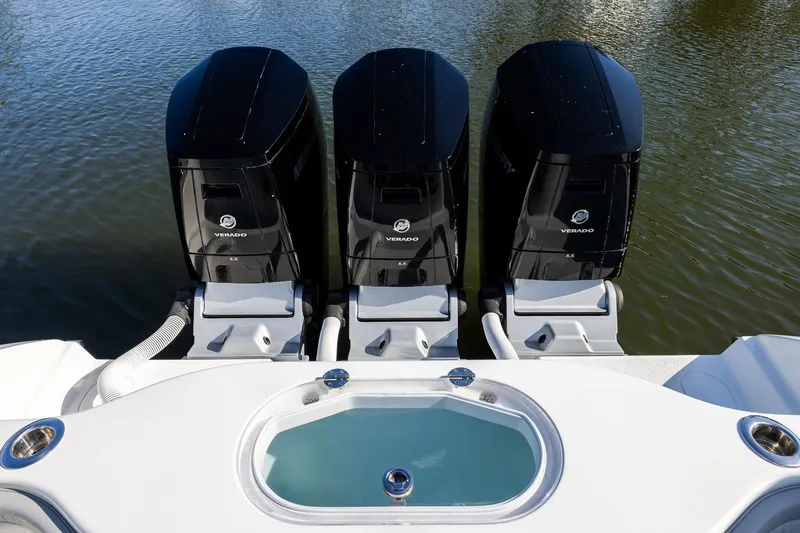Slide: The Image of Triple Verado engines on a 2023 Yellowfin 42 Offshore boat, docked on calm water. - 39