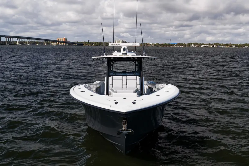 Slide: The Image of 2023 Yellowfin 42 Offshore boat on water, cloudy sky, bridge in background. - 4