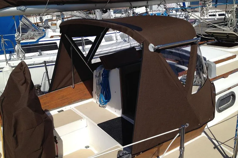 The Image of 1984 Cape Dory 31C sailboat with brown canvas cover docked at marina. - 0