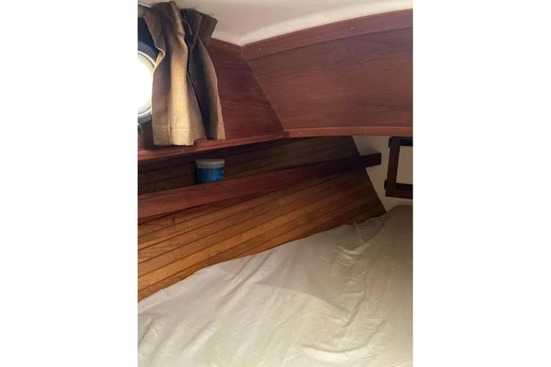 Slide: The Image of Interior cabin of 1984 Cape Dory 31C sailboat with wooden paneling and bedding. - 10