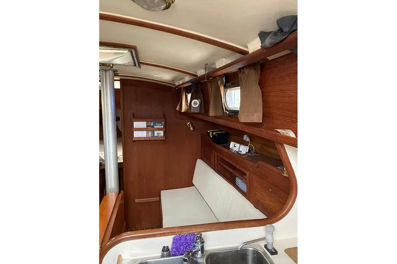 Slide: The Image of Interior of 1984 Cape Dory 31C sailboat with wooden cabinetry and seating area. - 12