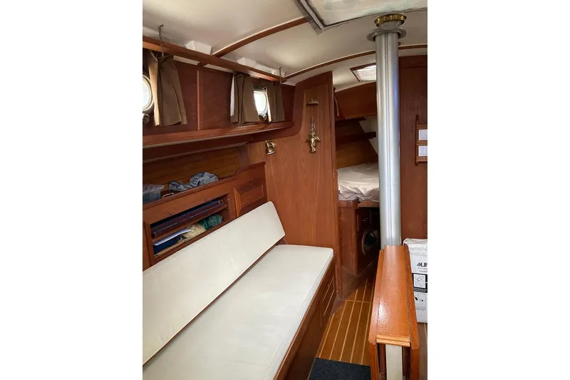 Slide: The Image of Interior of a 1984 Cape Dory 31C sailboat with wooden furnishings and cozy seating. - 13