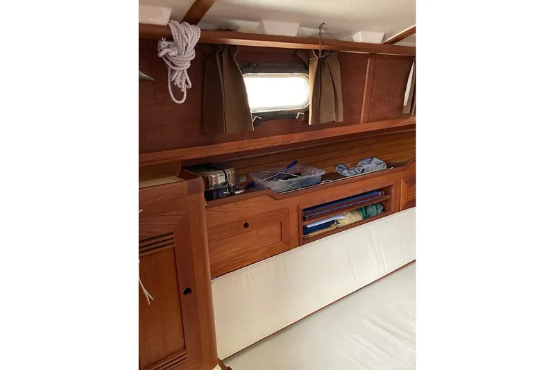 Slide: The Image of 1984 Cape Dory 31C yacht interior with wooden cabinetry and storage compartments. - 14