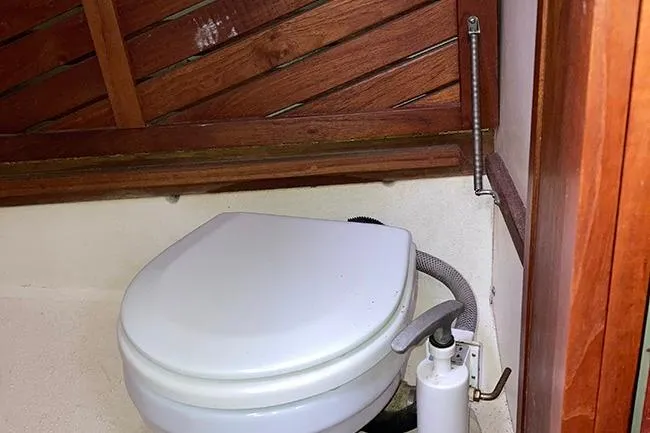 Slide: The Image of 1984 Cape Dory 31C boat bathroom with wooden paneling and marine toilet. - 19