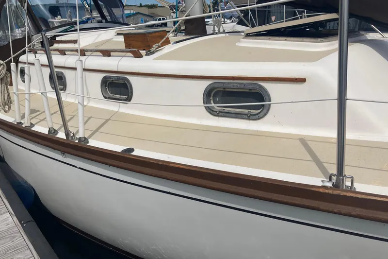 Slide: The Image of 1984 Cape Dory 31C sailboat docked, showcasing classic design and portholes. - 4