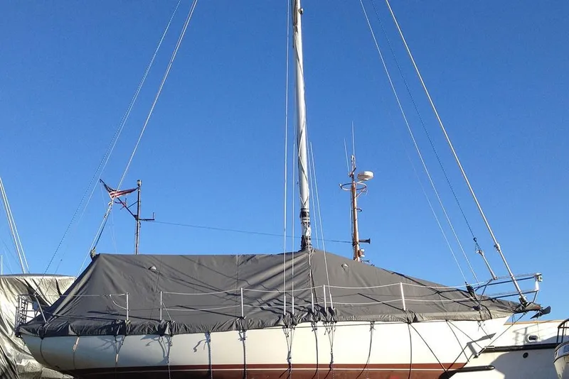 Slide: The Image of 1984 Cape Dory 31C sailboat covered, docked under clear blue sky. - 6
