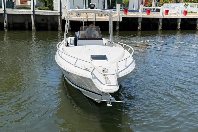 Slide: The Image of 2003 Intrepid 323 Cuddy boat navigating near a dock in calm waters. - 13