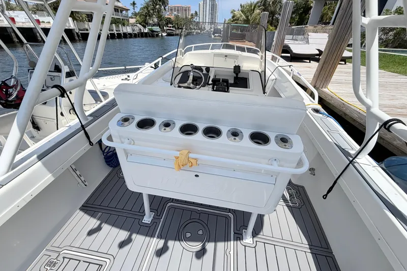 Slide: The Image of 2003 Intrepid 323 Cuddy boat interior with fishing rod holders and steering console. - 22