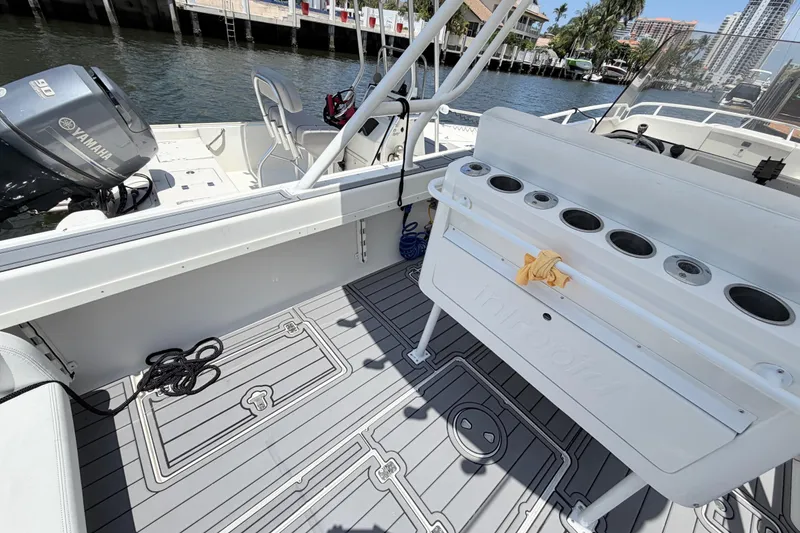 Slide: The Image of 2003 Intrepid 323 Cuddy boat interior with Yamaha engine, docked by waterfront homes. - 23
