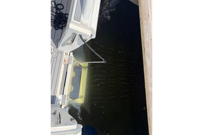 Slide: The Image of 2003 Intrepid 323 Cuddy boat stern view with dockside reflection. - 25