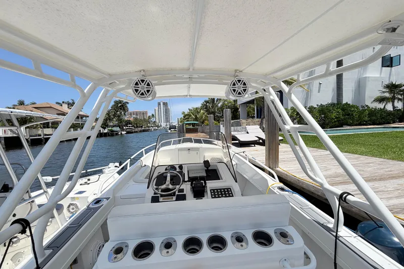 Slide: The Image of 2003 Intrepid 323 Cuddy boat docked by a canal with modern amenities. - 26