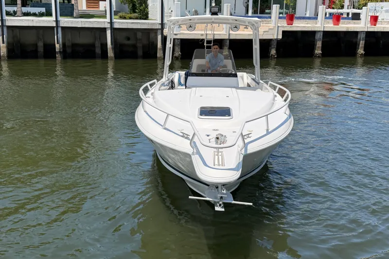 Slide: The Image of 2003 Intrepid 323 Cuddy boat cruising on calm water near a dock. - 3