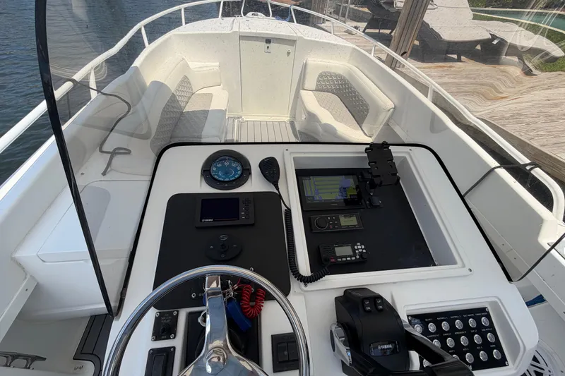 Slide: The Image of 2003 Intrepid 323 Cuddy boat helm with navigation instruments and steering wheel. - 30