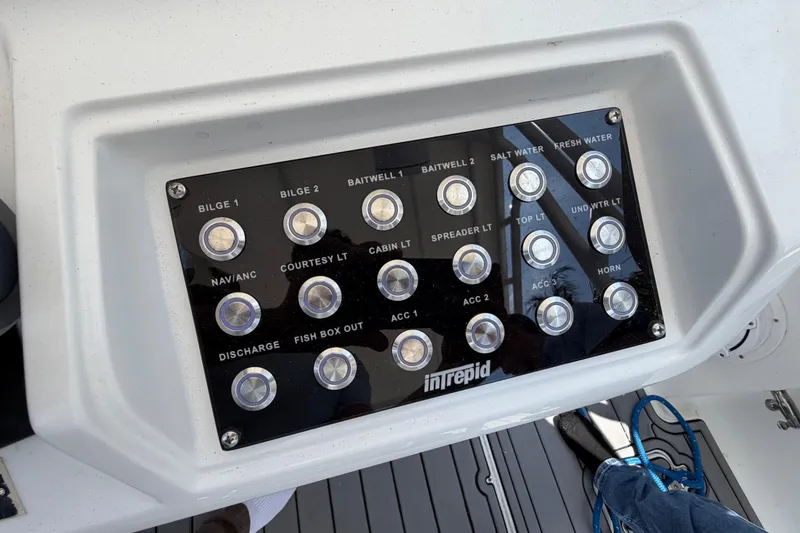 Slide: The Image of Control panel of a 2003 Intrepid 323 Cuddy boat with labeled switches. - 32