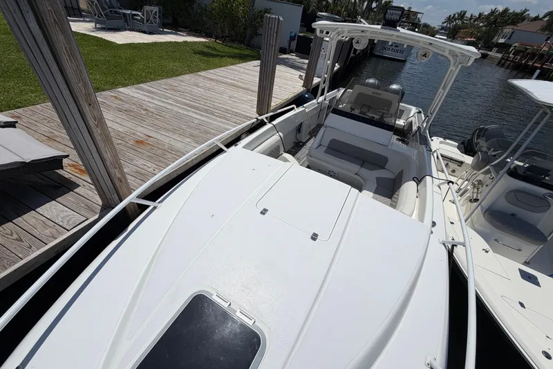 Slide: The Image of 2003 Intrepid 323 Cuddy boat docked by wooden pier, sunny day. - 34
