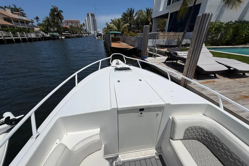 Slide: The Image of 2003 Intrepid 323 Cuddy boat docked by waterfront homes and palm trees. - 38