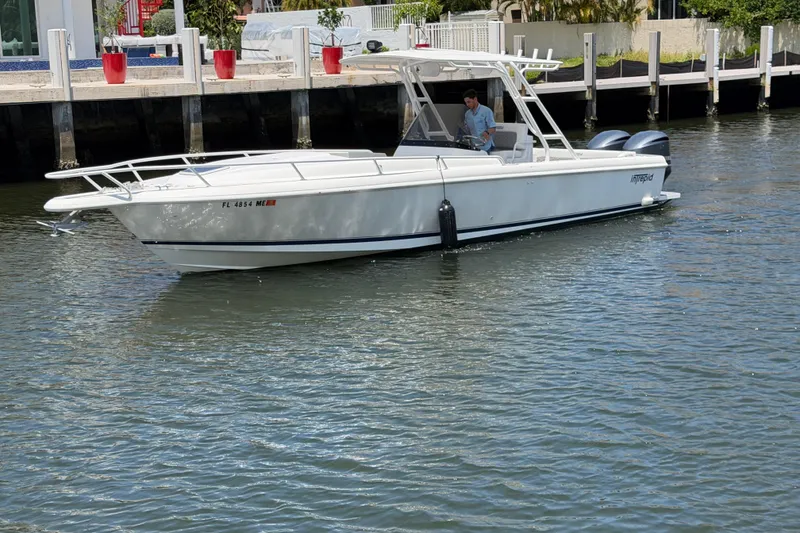 Slide: The Image of 2003 Intrepid 323 Cuddy boat cruising on calm water near a dock. - 4