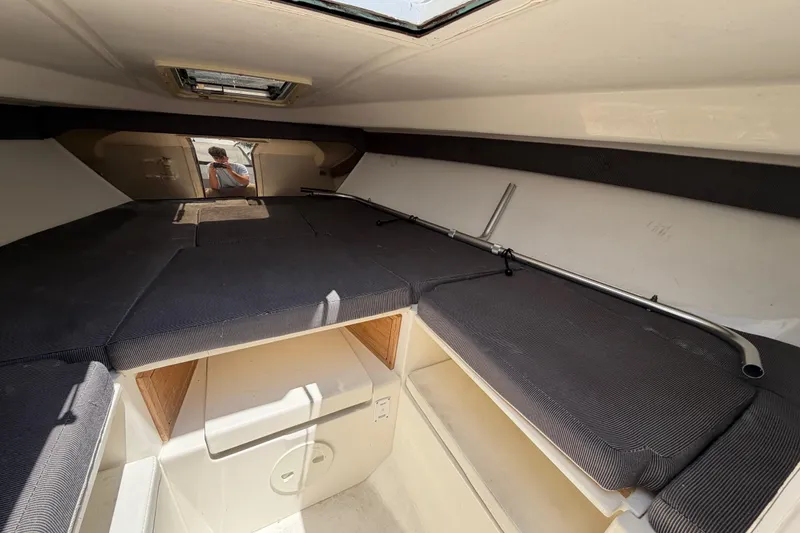 Slide: The Image of Interior cabin of a 2003 Intrepid 323 Cuddy boat, featuring cushioned seating. - 41