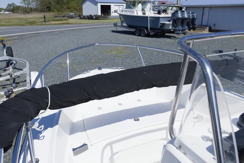 Slide: The Image of 2006 Edgewater 170CC boat with covered bow, parked on gravel near trailers. - 12
