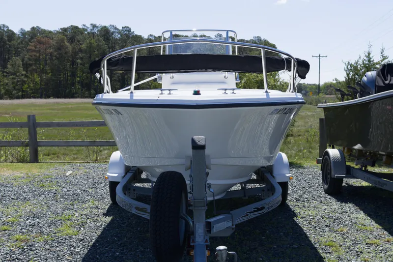 Slide: The Image of 2006 Edgewater 170CC boat on trailer, parked outdoors with trees in background. - 6