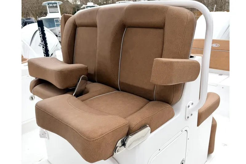 Slide: The Image of Brown cushioned seating on 2025 Sea Hunt Ultra 275 SE boat, featuring armrests and white frame. - 12