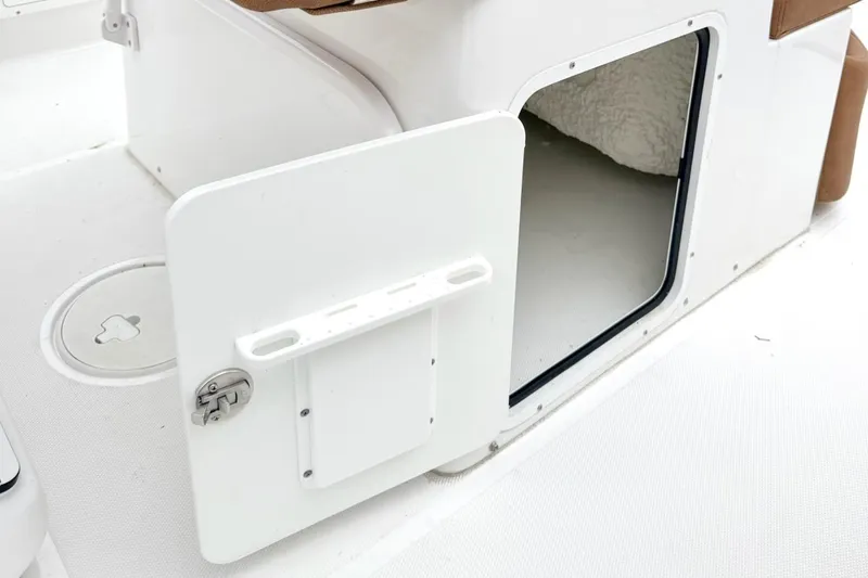 Slide: The Image of 2025 Sea Hunt Ultra 275 SE boat storage compartment with open door. - 13