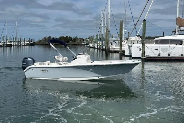 The Image of 2022 Sea Hunt Ultra 219 boat docked in a marina with sailboats in the background. - 1