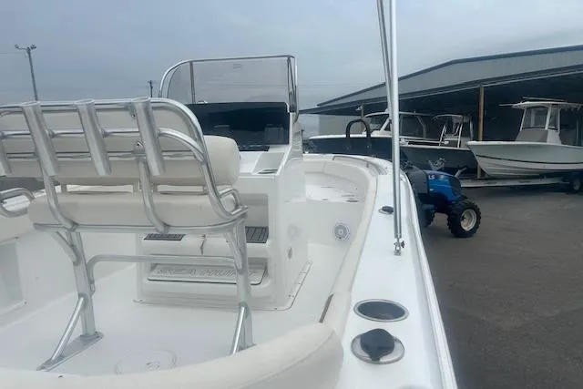 Slide: The Image of 2022 Sea Hunt Ultra 219 boat interior with seating and console, docked near other boats. - 6