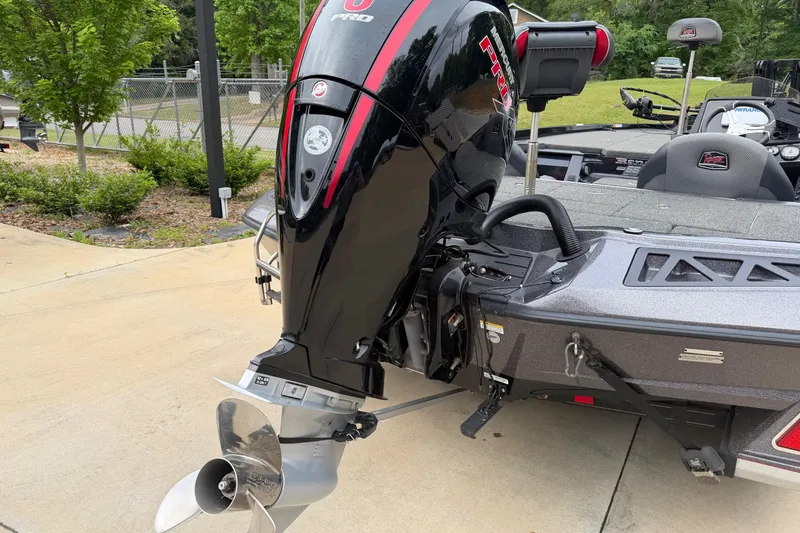 Slide: The Image of 2023 Ranger Z518 boat with powerful outboard motor, parked on concrete driveway. - 9
