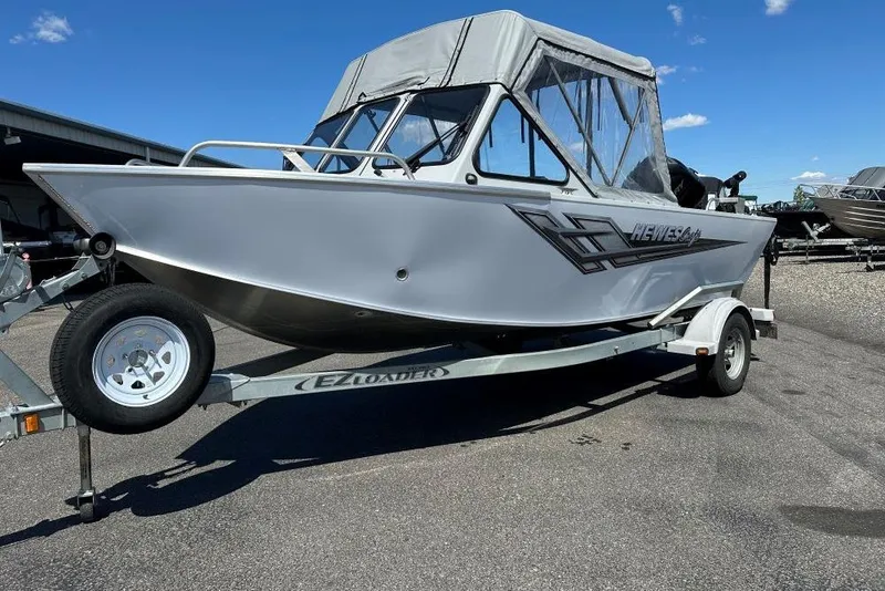 The Image of 2015 Hewescraft 180 Sportsman boat on EZ Loader trailer, parked outdoors under clear sky. - 1
