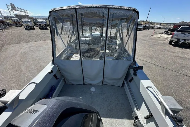 Slide: The Image of 2015 Hewescraft 180 Sportsman boat with canopy, parked in a lot under clear skies. - 4