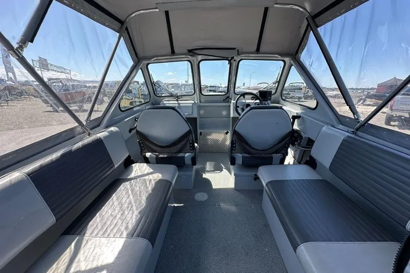Slide: The Image of Interior of a 2015 Hewescraft 180 Sportsman boat with seating and steering wheel. - 5