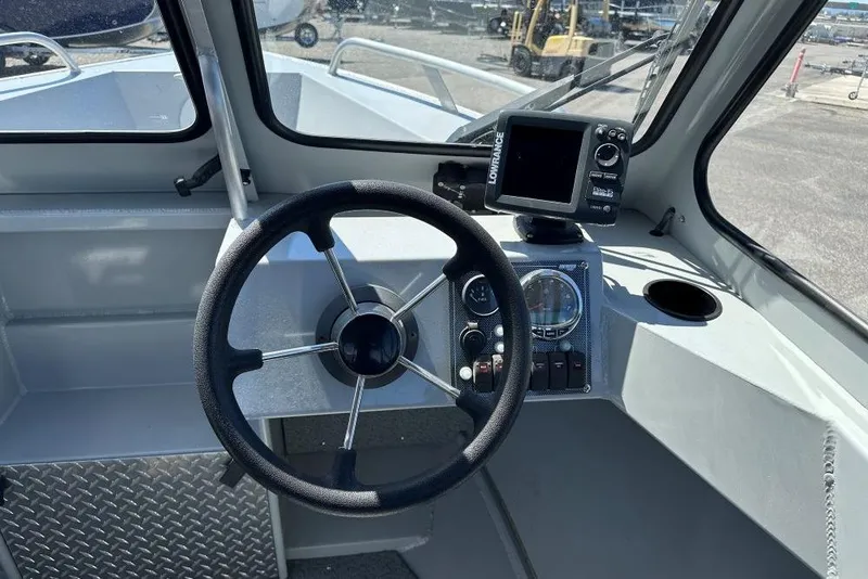 Slide: The Image of 2015 Hewescraft 180 Sportsman boat dashboard with steering wheel and navigation system. - 6
