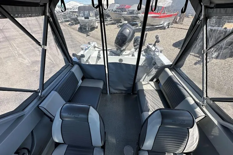 Slide: The Image of Interior of a 2015 Hewescraft 180 Sportsman boat with seating and canopy. - 7