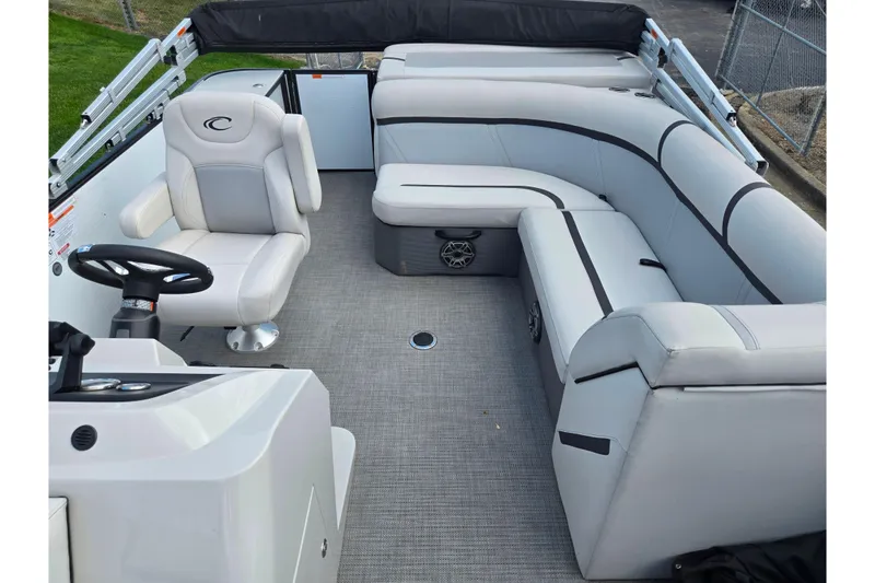 Slide: The Image of 2023 Crest Classic LX 200 pontoon boat interior with plush seating and steering console. - 12