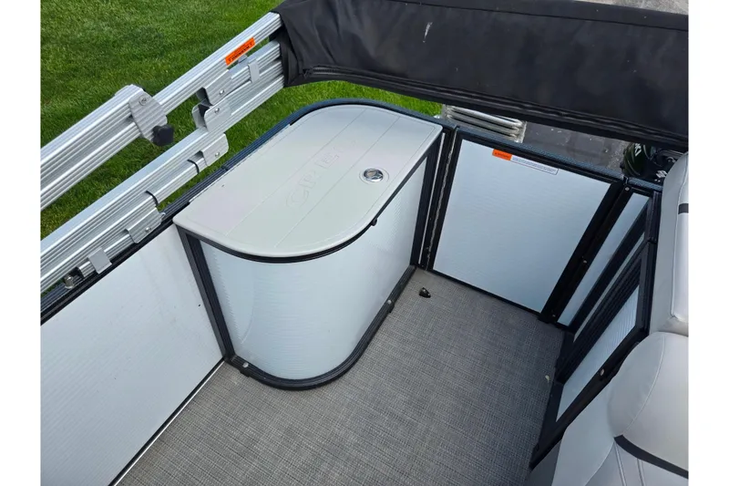 Slide: The Image of 2023 Crest Classic LX 200 boat interior with storage compartment and seating area. - 14