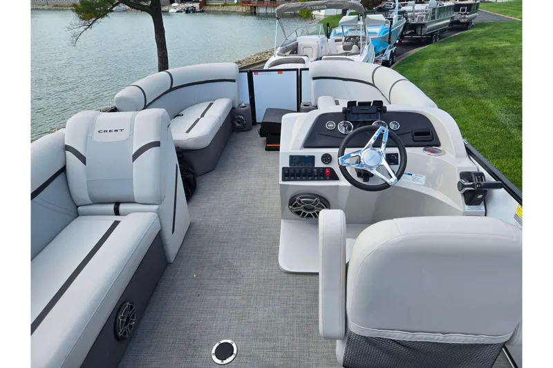 Slide: The Image of 2023 Crest Classic LX 200 pontoon boat interior with modern helm and plush seating. - 18
