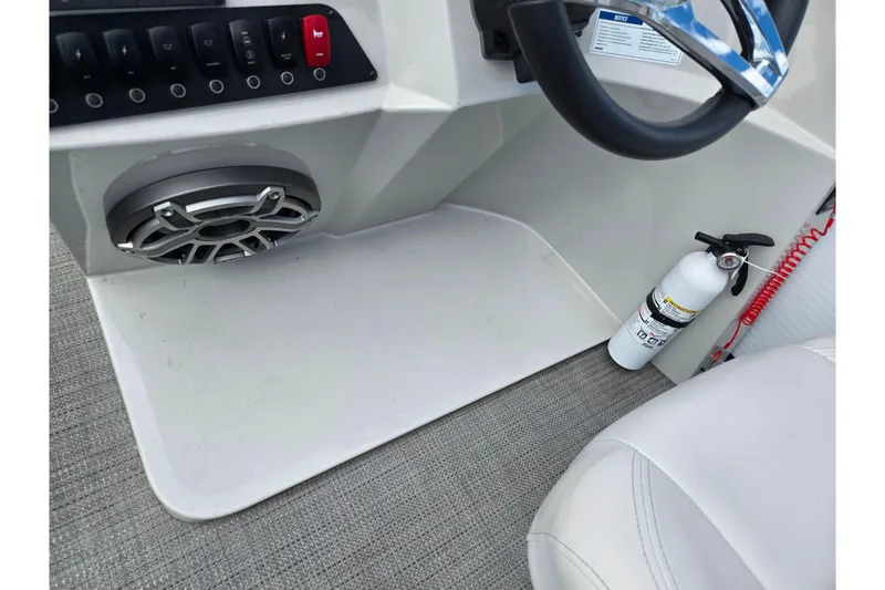 Slide: The Image of 2023 Crest Classic LX 200 boat interior with steering wheel, speaker, and fire extinguisher. - 21
